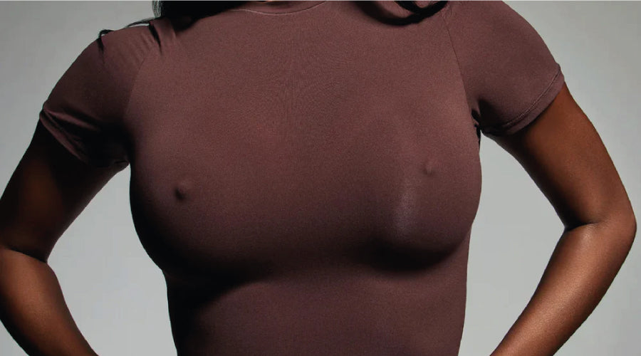 Woman wearing a Kim Kardashian nipple push up bra worn under a skin tight brown t-shirt