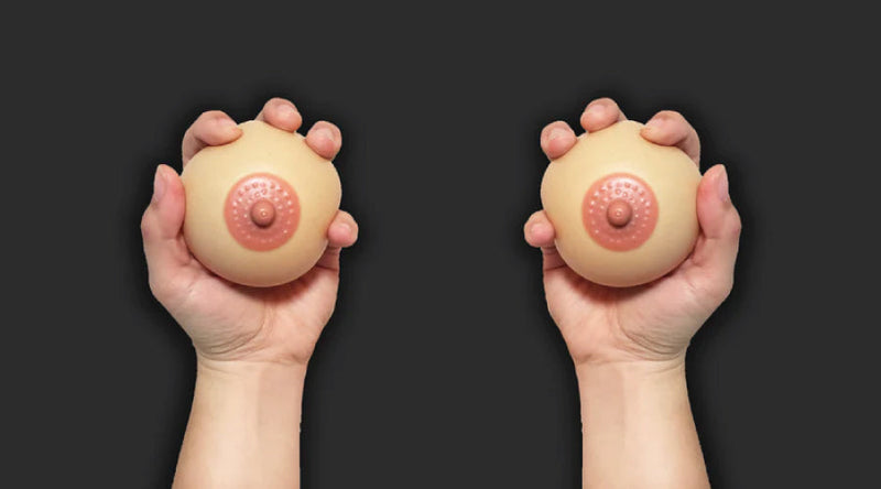 Pair of hands holding two stress balls against a black background