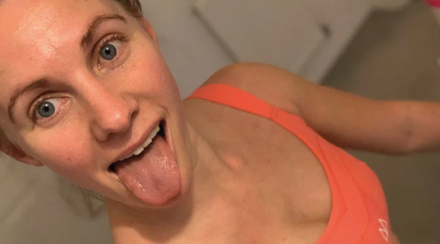 Girl sticking her tong out whist wearing a coral maaree sports bra