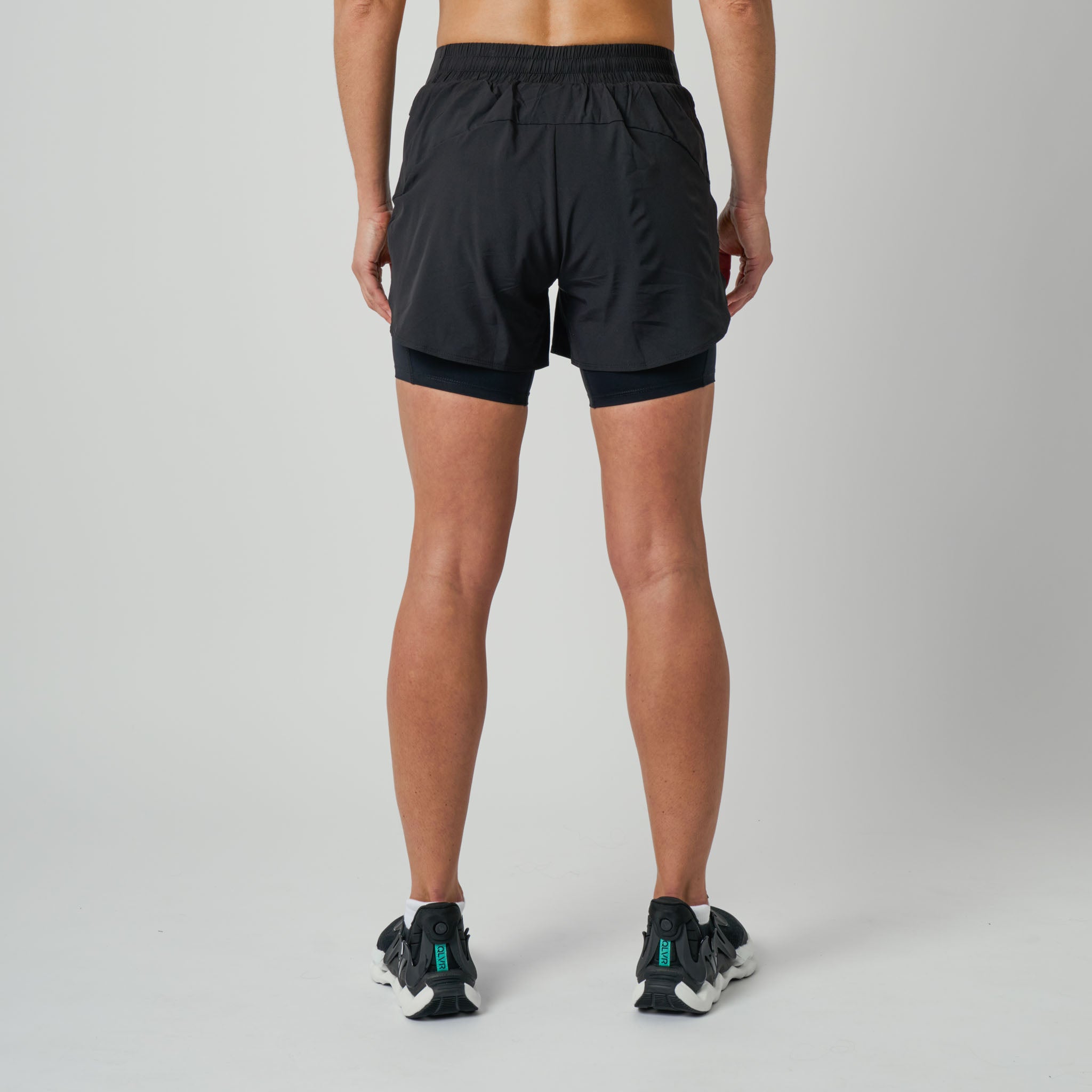 Person wearing black athletic shorts on a gray background
