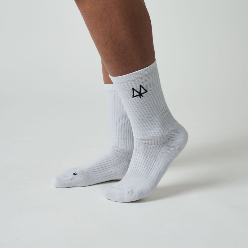 White socks with a black logo worn by a person on a light gray background
